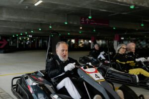Seniors indulging in indoor go-karting, fostering camaraderie and recreation.